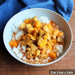 A tempting bowl of Thai Red Curry with succulent chicken and chunks of butternut squash, served atop a mound of perfectly cooked jasmine rice.