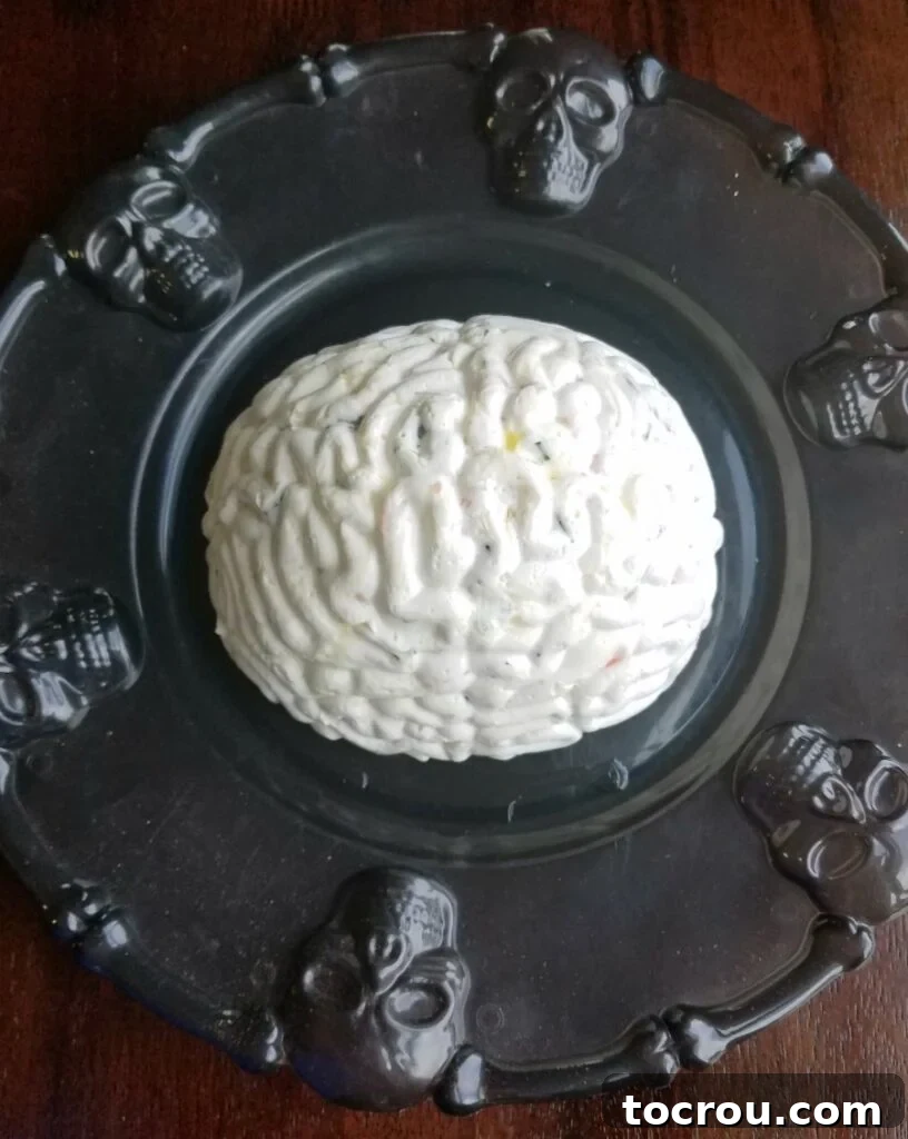 Brain-shaped shrimp spread proudly displayed on a black skull platter, perfect for a Halloween party.