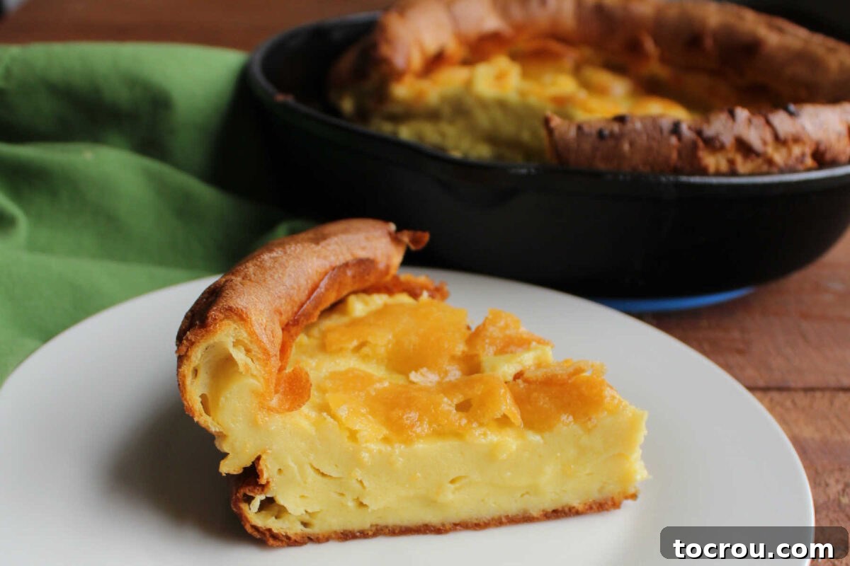 Mimi's Golden Custard Delight 6 Slice of custard dutch baby showing puffed up edges and denser custard-like center.