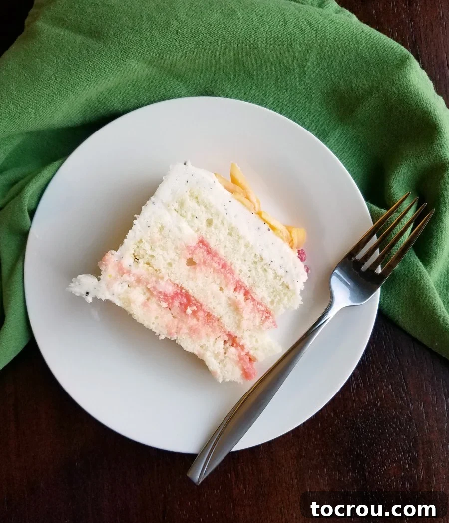 slice of white cake with pink blood orange curd filling between layers.