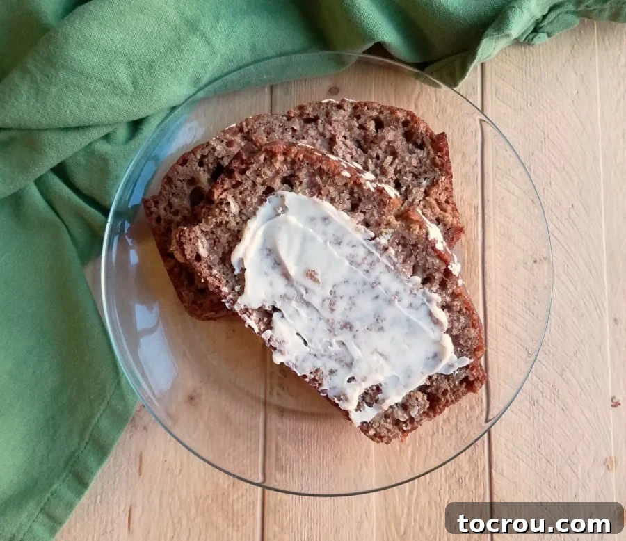 Several appetizing slices of oatmeal applesauce bread, each lovingly adorned with a smooth smear of vanilla honey butter, presented on a platter.