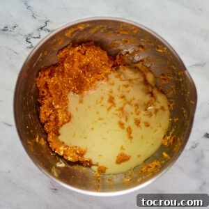 Adding condensed milk and orange zest to the filling mixture.