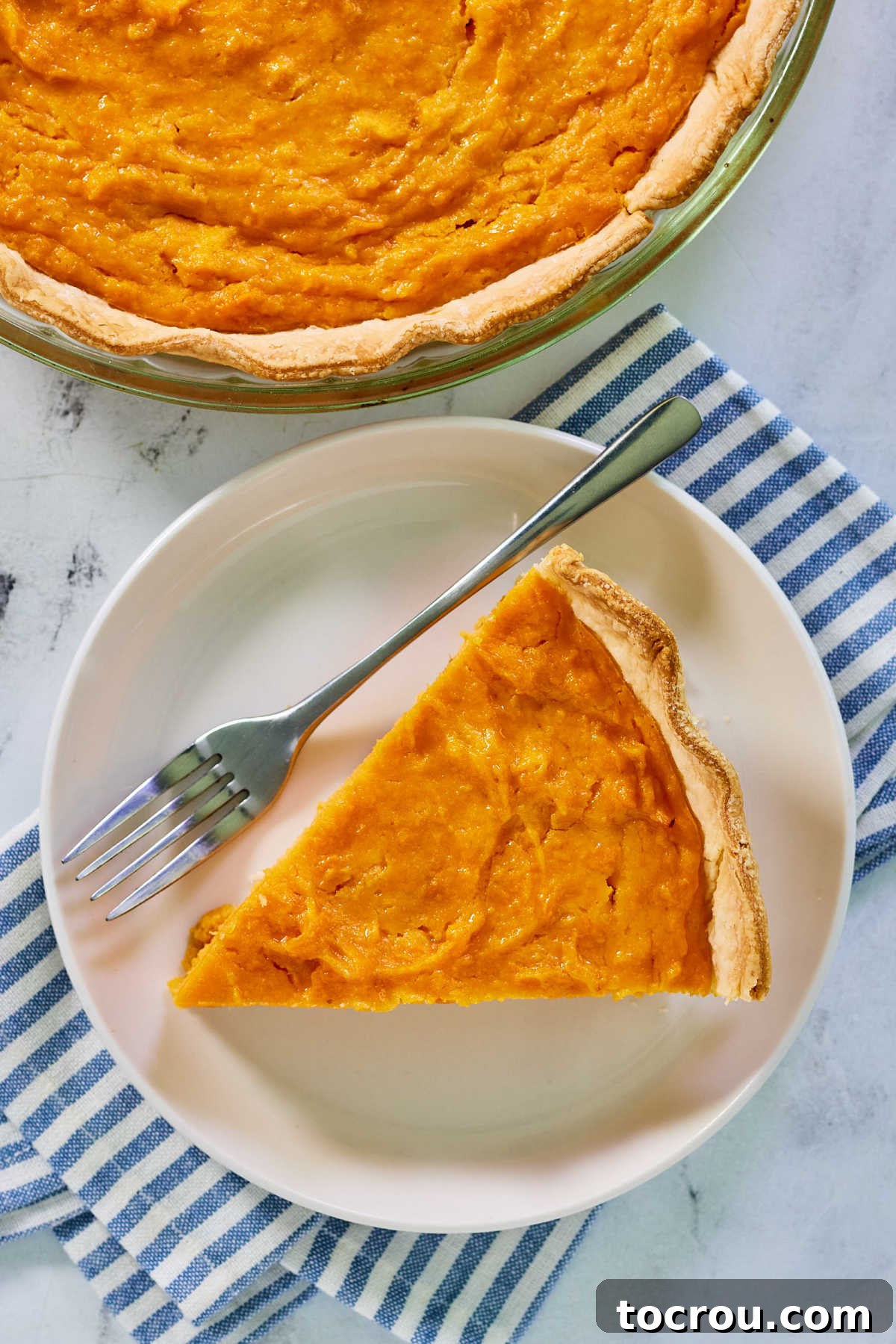 Decadent Sweet Potato Pie with Condensed Milk 4 Looking down on a plate with a slice of condensed milk sweet potato pie and a fork.