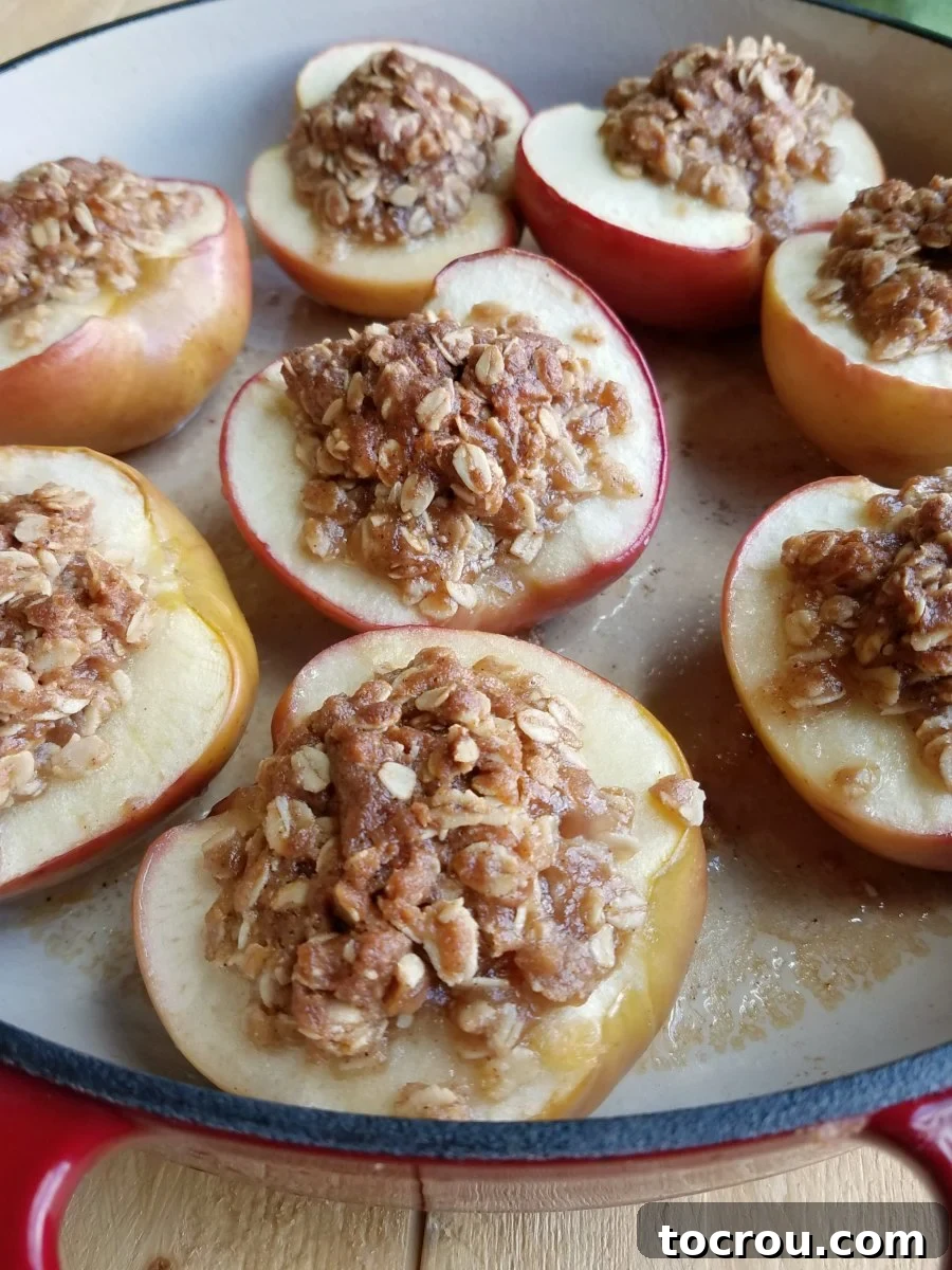pan filled with baked apple halves topped with oatmeal mixture.
