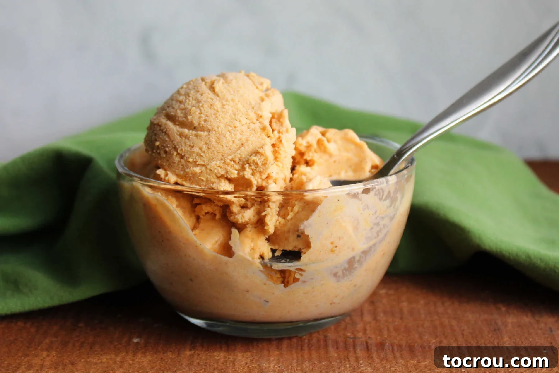 Velvet Pumpkin Ice Cream 2 Bowl of creamy homemade pumpkin ice cream with a spoon, ready to eat.