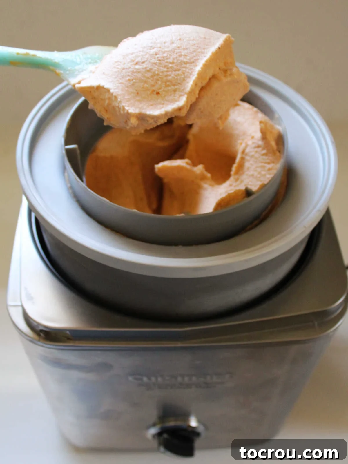 Velvet Pumpkin Ice Cream 4 Spatula lifting churned pumpkin ice cream out of the ice cream machine, ready to go into storage containers.