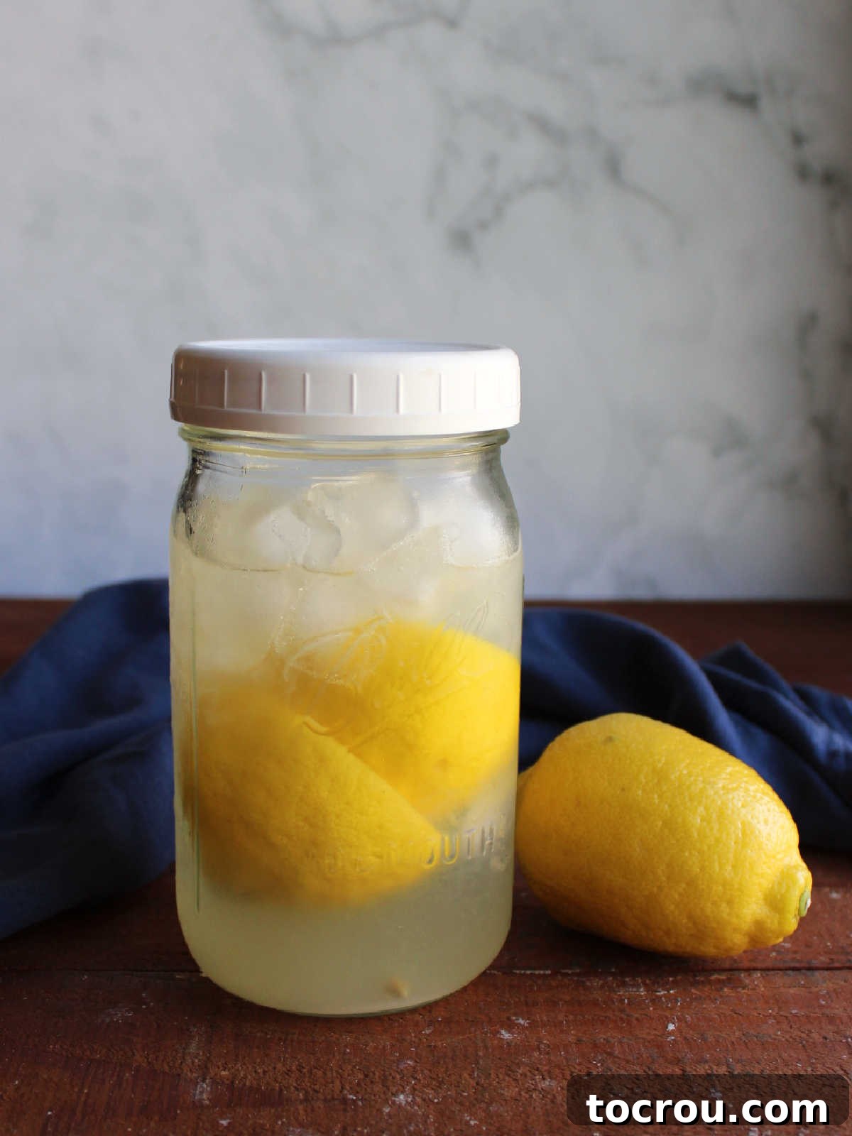 Tangy Shaken Lemonade 4 Quart jar with homemade lemonade inside and plastic lid on top after it has been shook to dissolve the sugar.