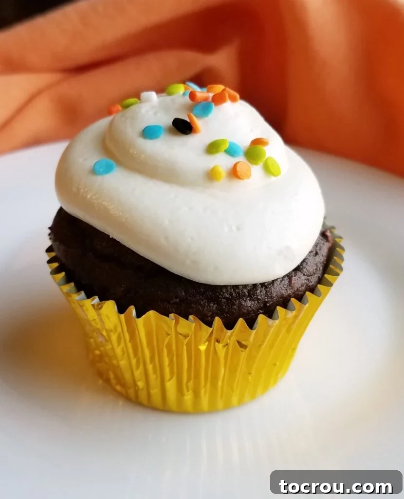 Cupcake with Whipped Frosting Decadent chocolate pumpkin cupcake crowned with smooth white whipped sweetened condensed milk frosting.