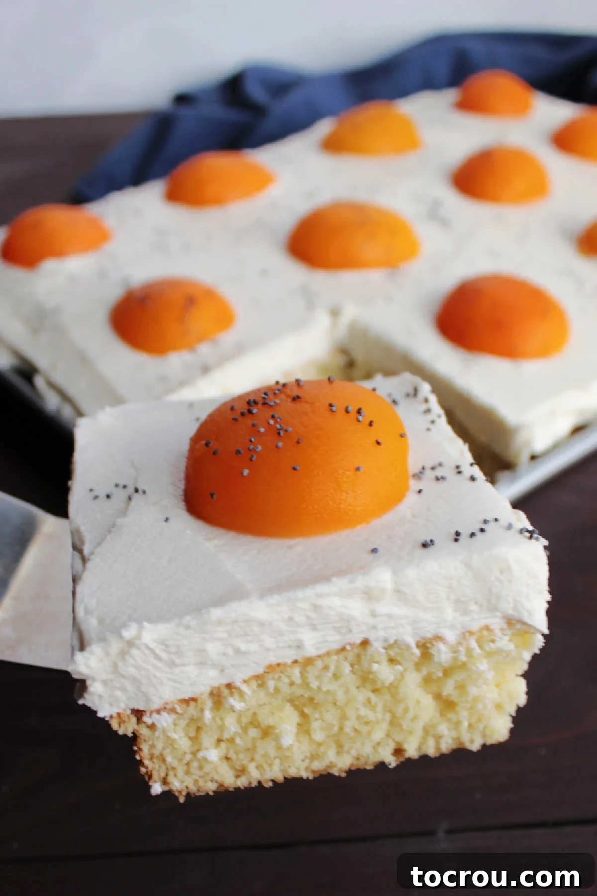 Serving Sunny Side Up Cake Spatula carefully lifting a slice of sunny side up cake out of a pan, highlighting the creative application of the frosting.