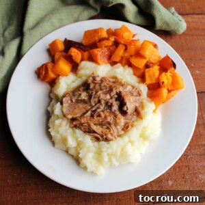 Slow cooked apple cider pulled pork served on mashed potatoes with a side of roasted butternut squash.