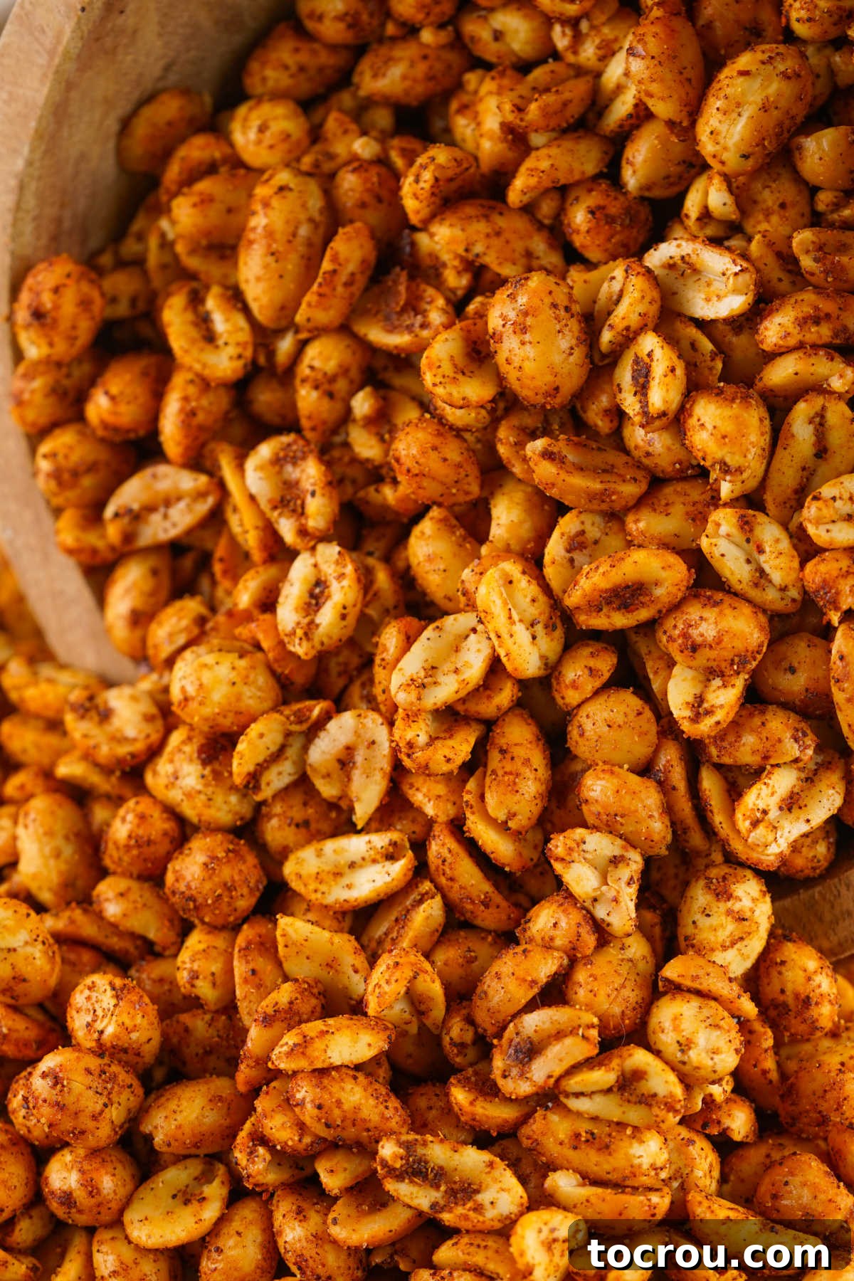 Zesty Peanuts 7 Close up of perfectly coated spicy peanuts, showcasing the reddish chili powder, cayenne, and garlic spices clinging to each nut, enhancing their visual appeal and flavor.