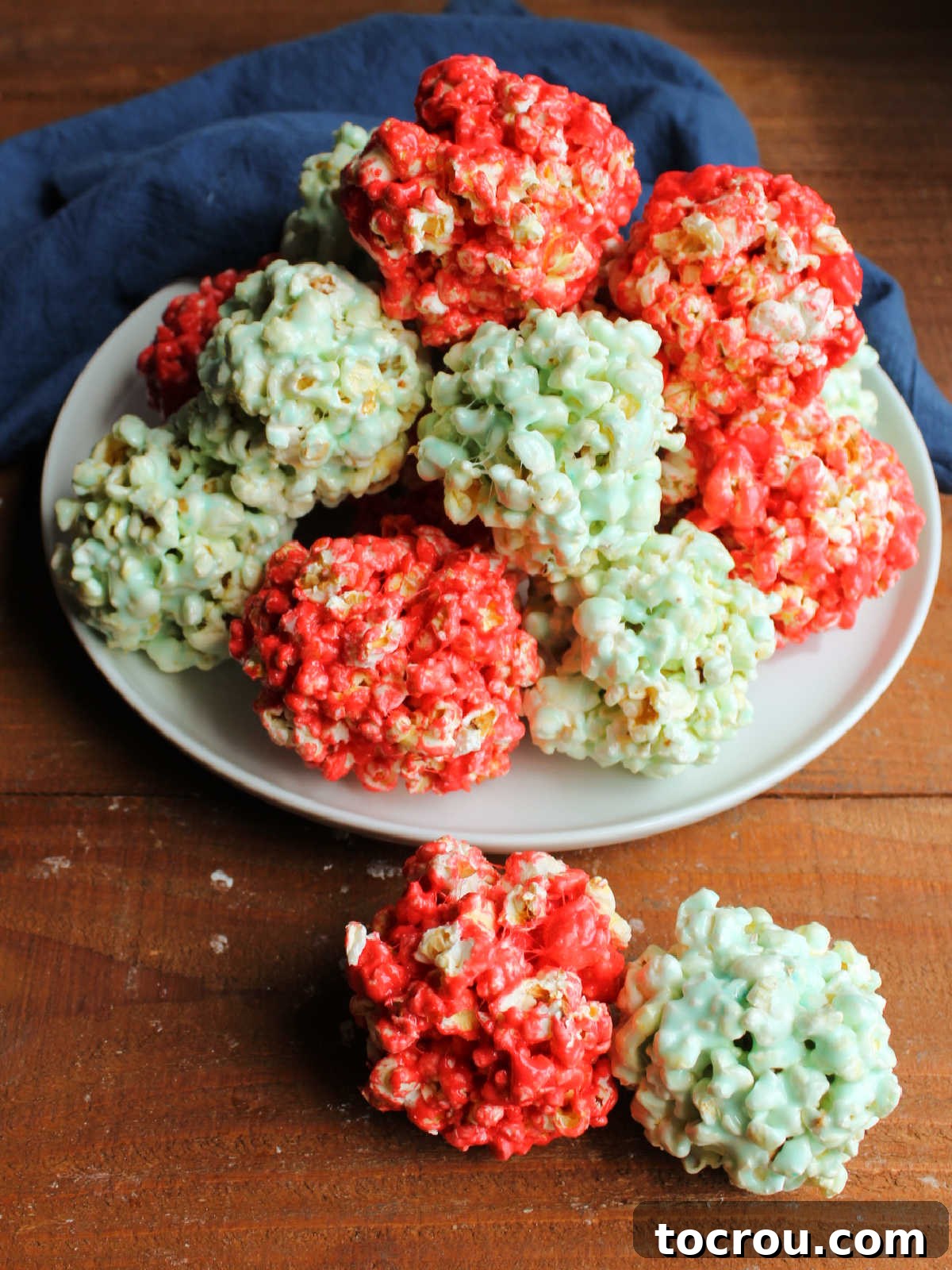 Platter of red and light blue popcorn balls, held together by marshmallow and Jell-O powder, giving them color and flavor.