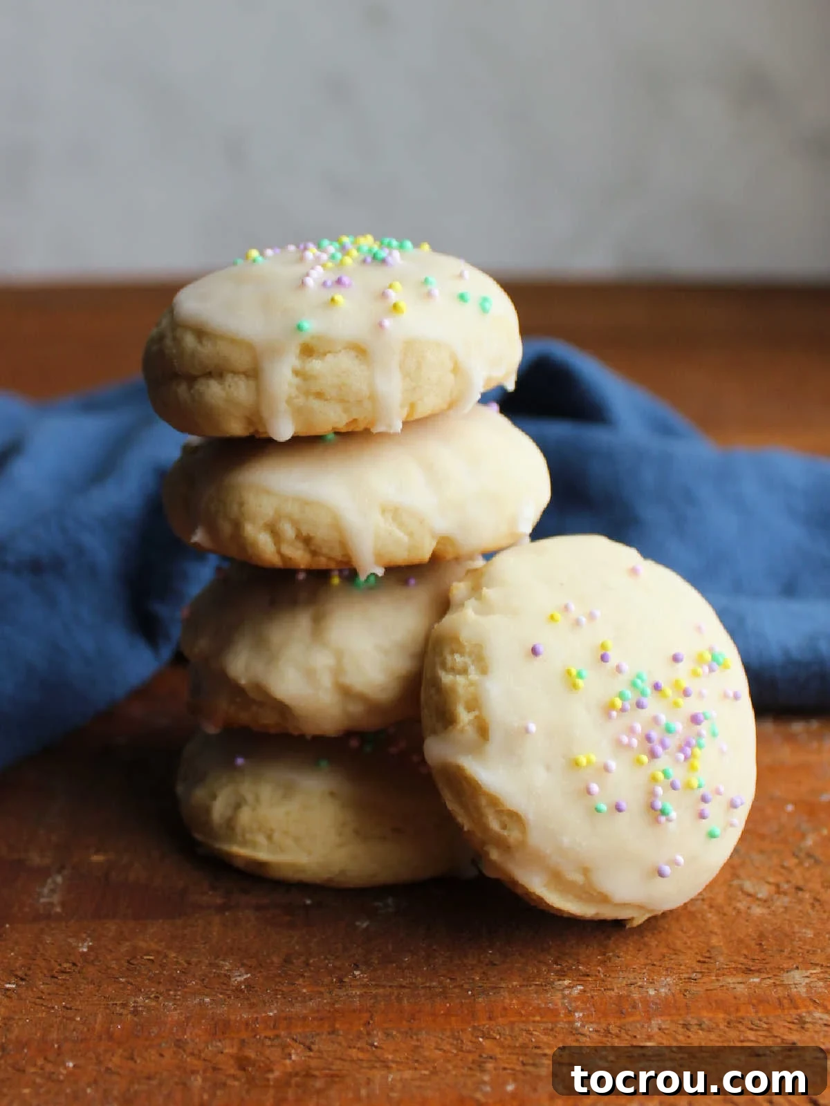 Heirloom Tea Cakes 3 A charming stack of thick, perfectly baked tea cake cookies, each generously topped with a sweet glaze and delicate sprinkles, ready to be devoured.