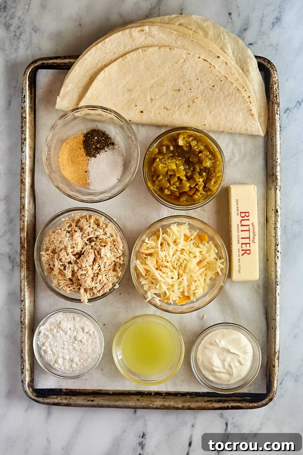 Enchilada Ingredients Ingredients for creamy white chicken enchiladas, including shredded chicken, Monterey Jack cheese, flour tortillas, sour cream, chicken broth, butter, flour, green chiles, and seasonings.