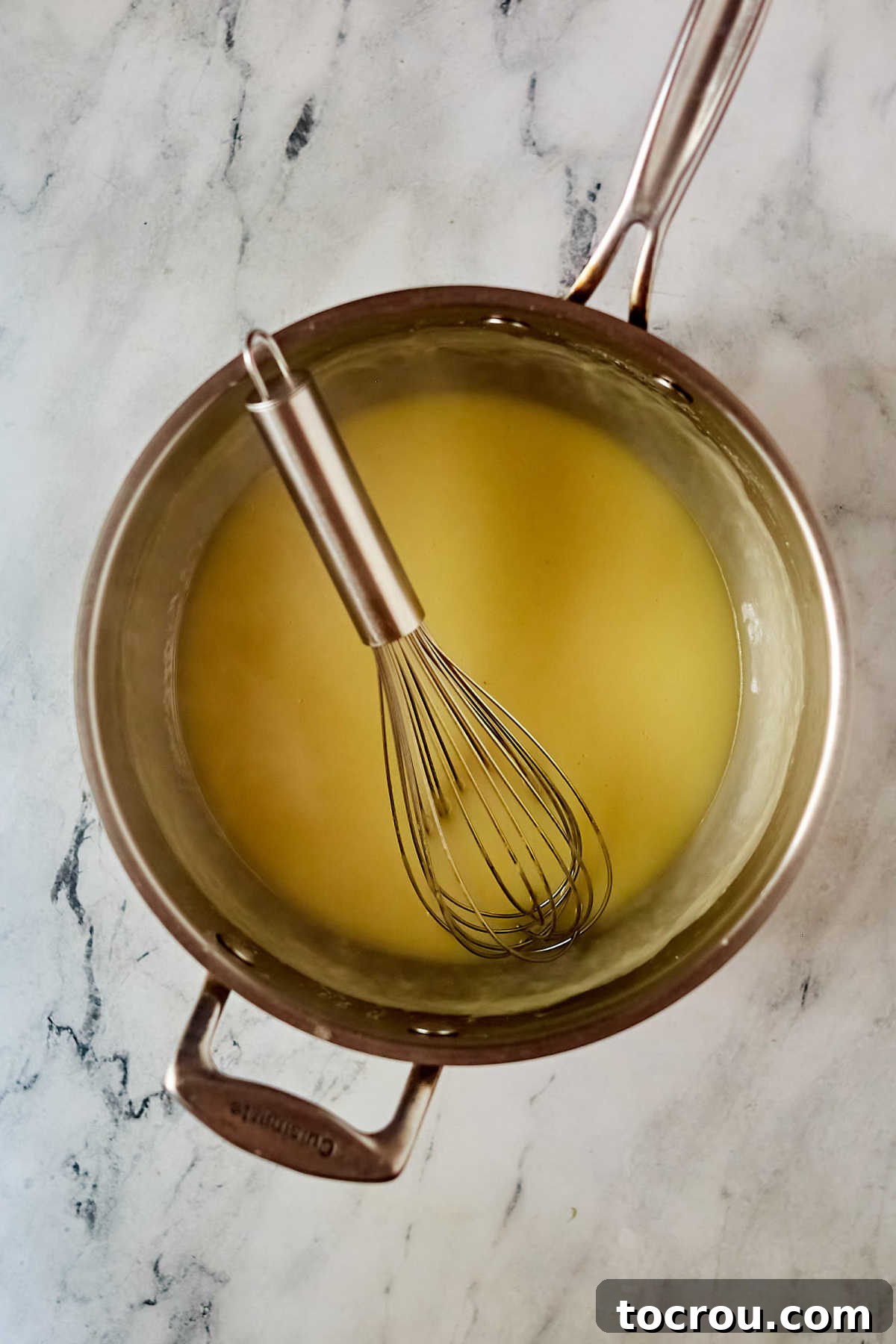 Sauce Base Thickening Thickened chicken broth and roux simmering in a saucepot, ready for cheese to be added for the creamy enchilada sauce.