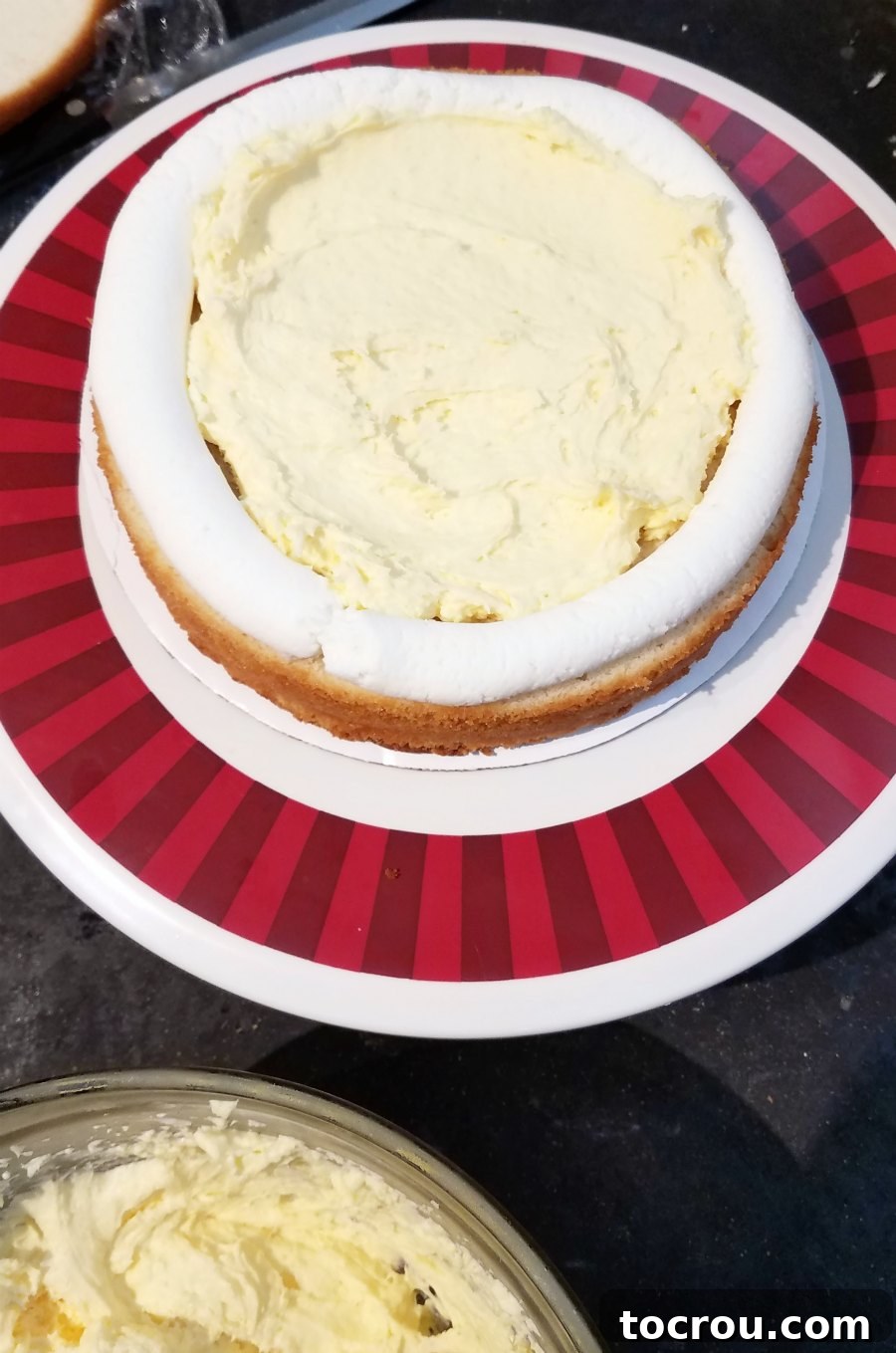 Effortless Pudding Cake Layer 5 Round cake with buttercream frosting dam around the edge and creamy vanilla pudding filling in the middle.