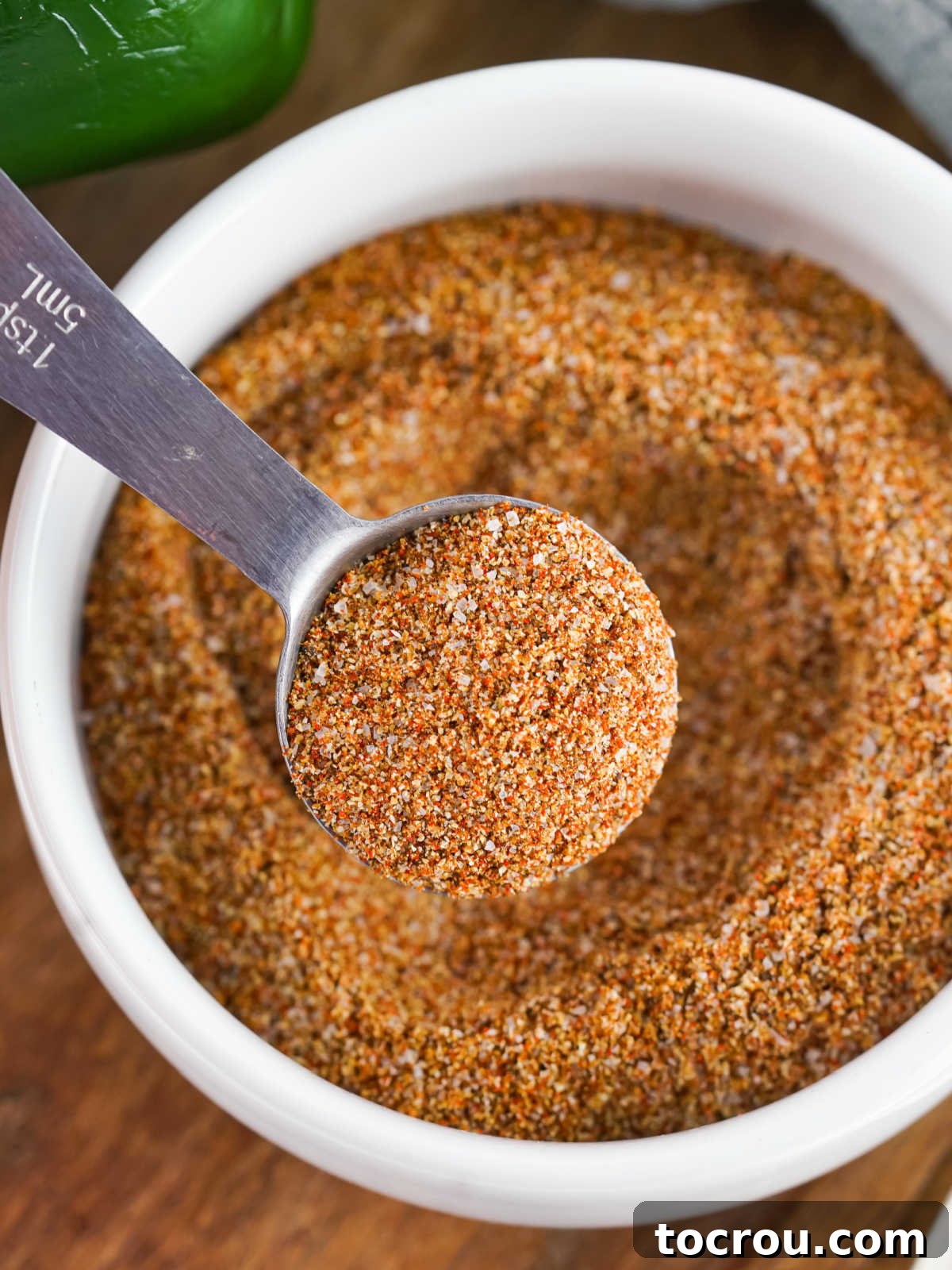 Scooping Homemade Fajita Seasoning Close up of a small bowl of homemade fajita seasoning with a tablespoon getting a scoop out to use.
