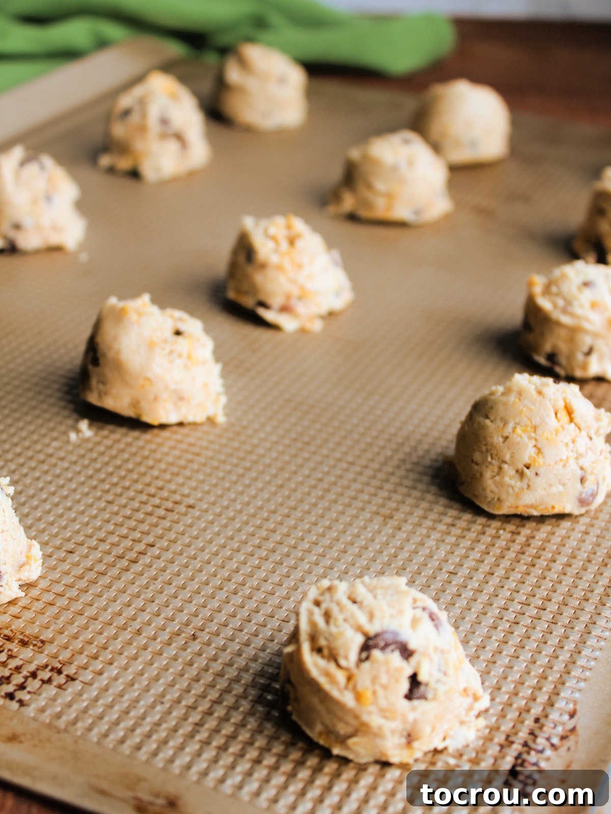 Scoops of cornflake cookie dough with chocolate chips and oats inside, ready to bake.