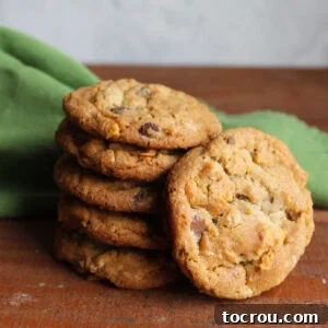 Stack of golden brown cornflake cookies with chocolate chips and oatmeal, showing texture.