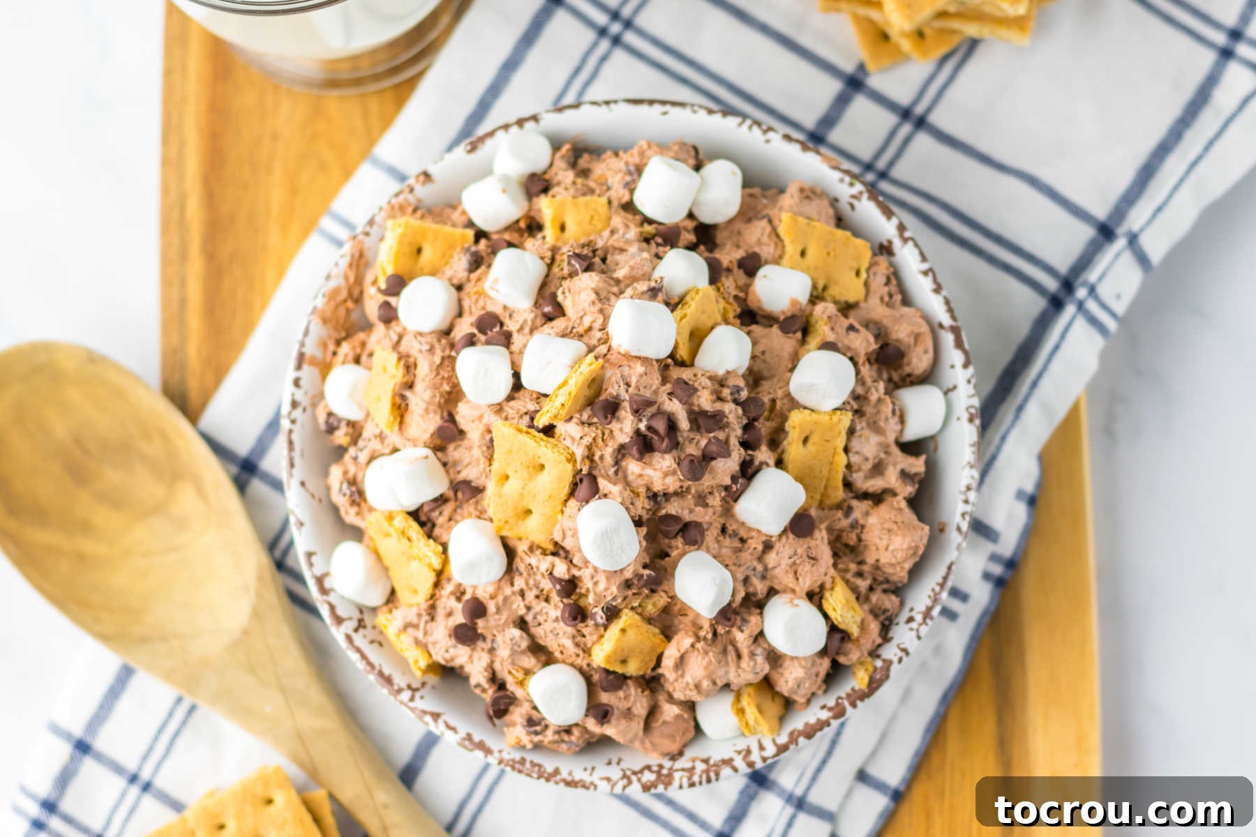 Smores Cloud 2 Bowl of fluffy chocolate s'mores fluff topped with chocolate chips, bits of graham crackers, and mini marshmallows, ready to be served.