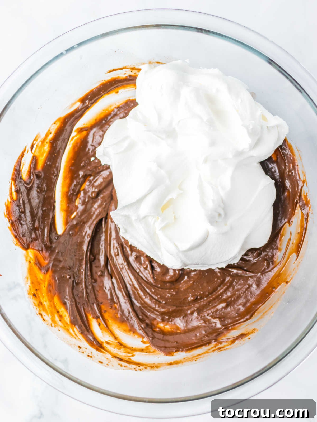 Smores Cloud 4 large mixing bowl with thick chocolate pudding mixture and cool whip, ready to be folded together.