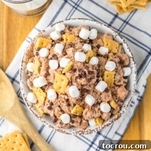 Smores Cloud 9 Serving bowl piled with chocolate s'mores fluff topped with bits of graham crackers, mini chocolate chips, and mini marshmallows.