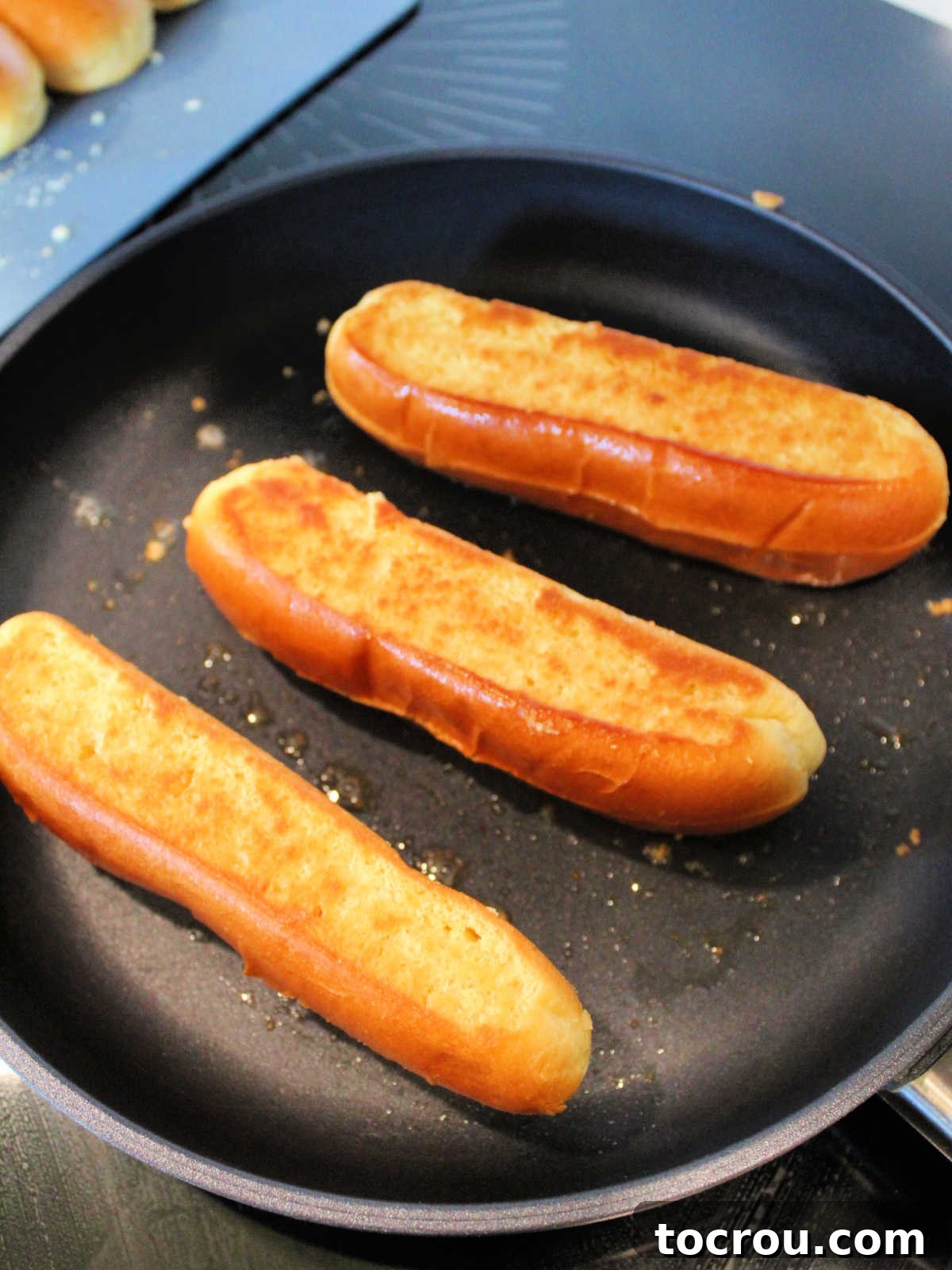 Toasting trimmed brioche buns in skillet before 