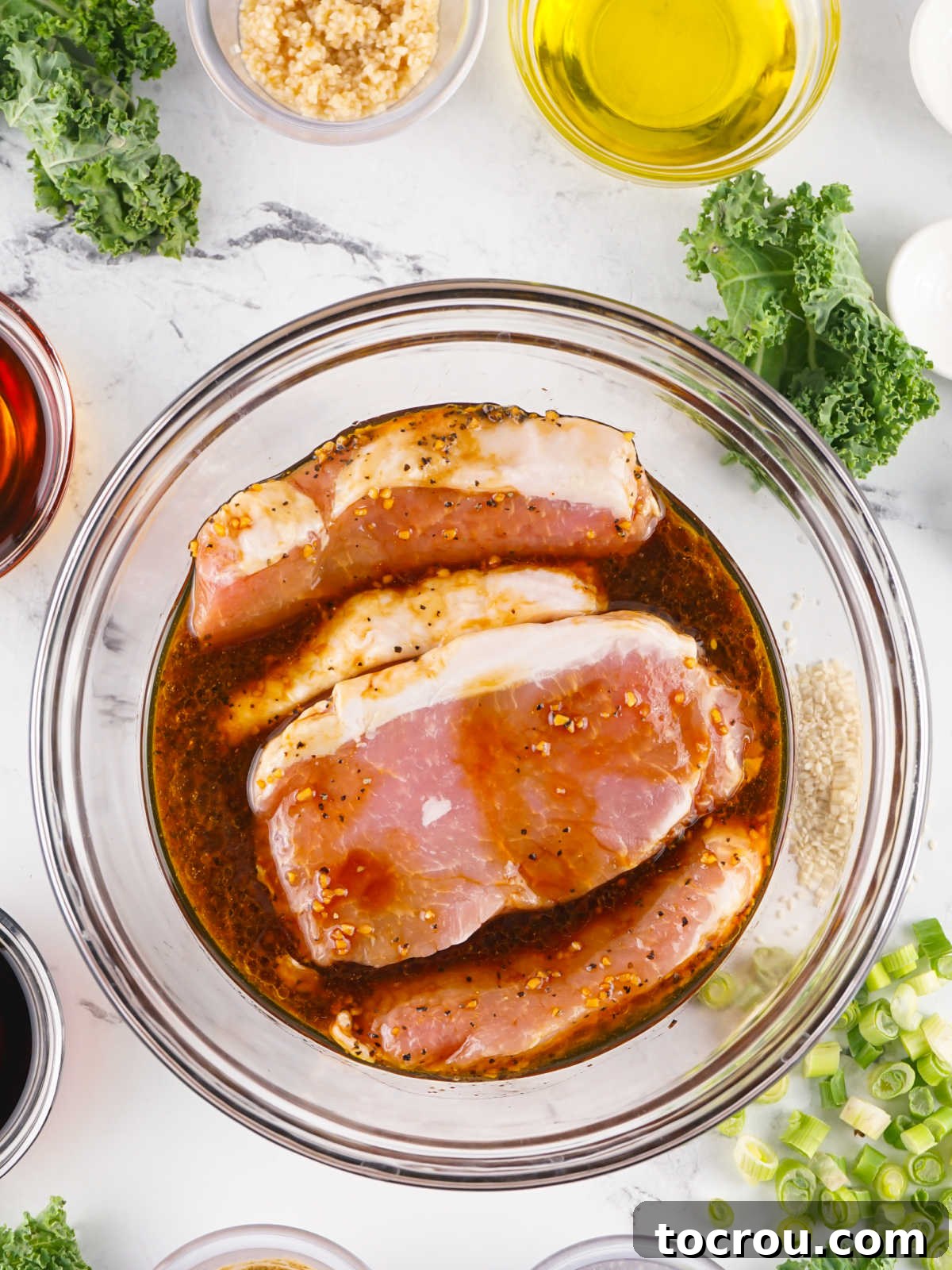 Pork chops soaking in marinade mixture before they are cooked. 