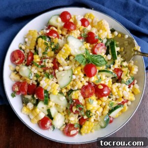 Bowlful of corn salad with cherry tomatoes, basil, cucumbers and fresh corn.