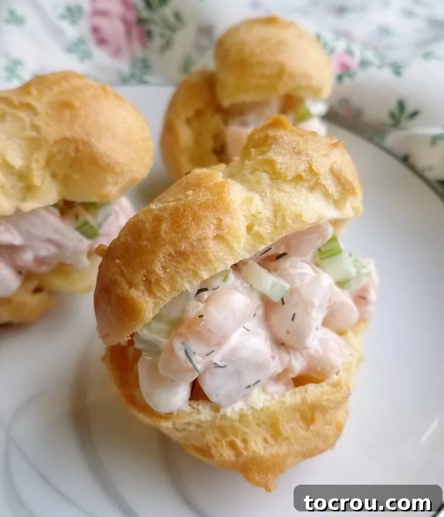 Savory Shrimp Profiterole Bites 2 Shrimp salad with creamy dressings and bits of celery inside a golden brown choux pastry profiterole.