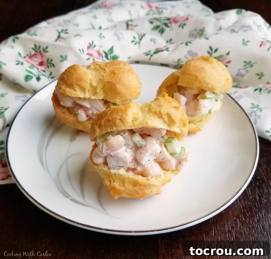 Savory Shrimp Profiterole Bites 7 small plate filled with shrimp salad puffs ready to eat.