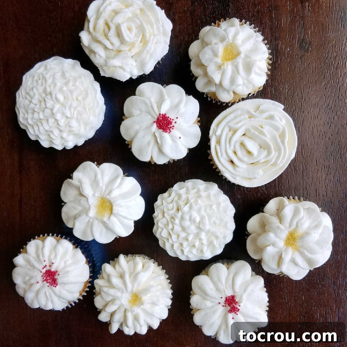 cupcakes topped with various piped buttercream flower designs.
