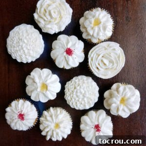cupcakes topped with various piped buttercream flower designs.