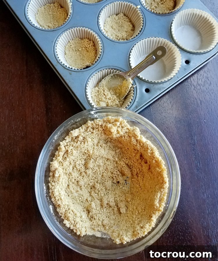 Toasted Marshmallow S'mores Cupcakes 3 putting graham cracker crust into cupcake liners for s'mores cupcakes.