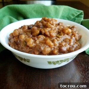 Bowl of cowboy beans with thick and rich baked beans loaded with ground beef and goodies.