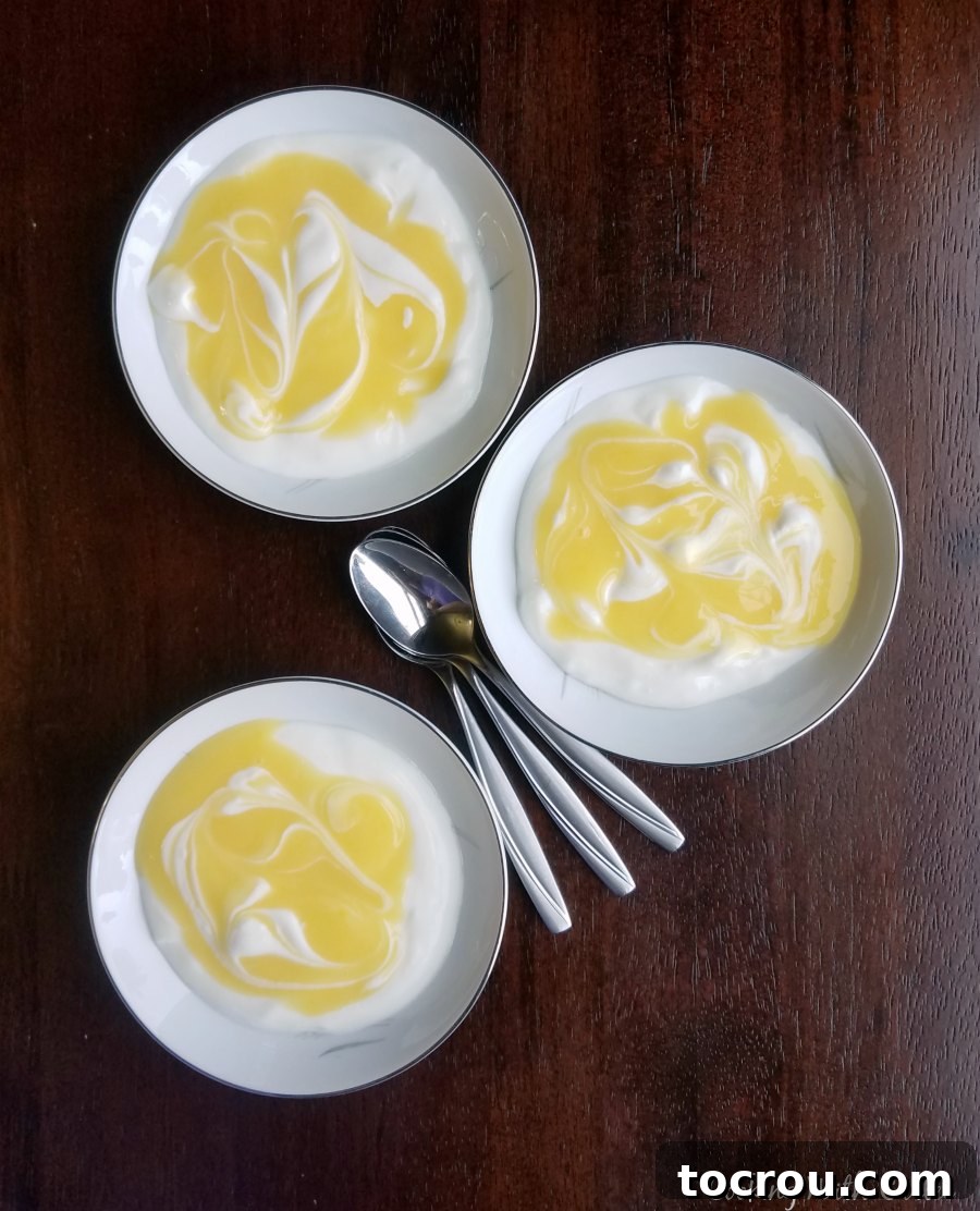 Lemon Curd Yogurt Bowls Three small bowls of yogurt topped with lemon curd and granola, showcasing various serving possibilities.