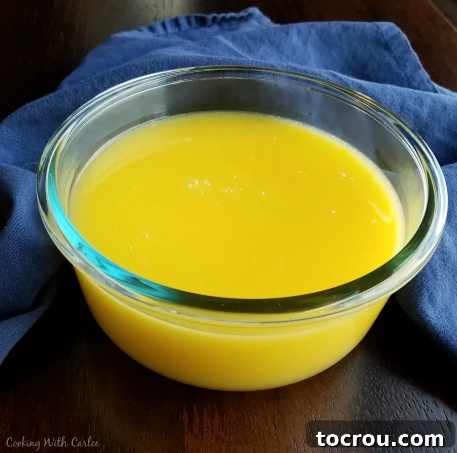 Freshly Made Lemon Curd Glass bowl filled with freshly made, vibrant yellow lemon curd, showcasing its smooth texture.