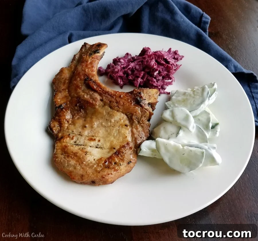 Golden Glazed Honey Mustard Chops 2 Dinner plate with honey mustard grilled bone in pork chop, creamy cucumber salad, and shaved beet salad.