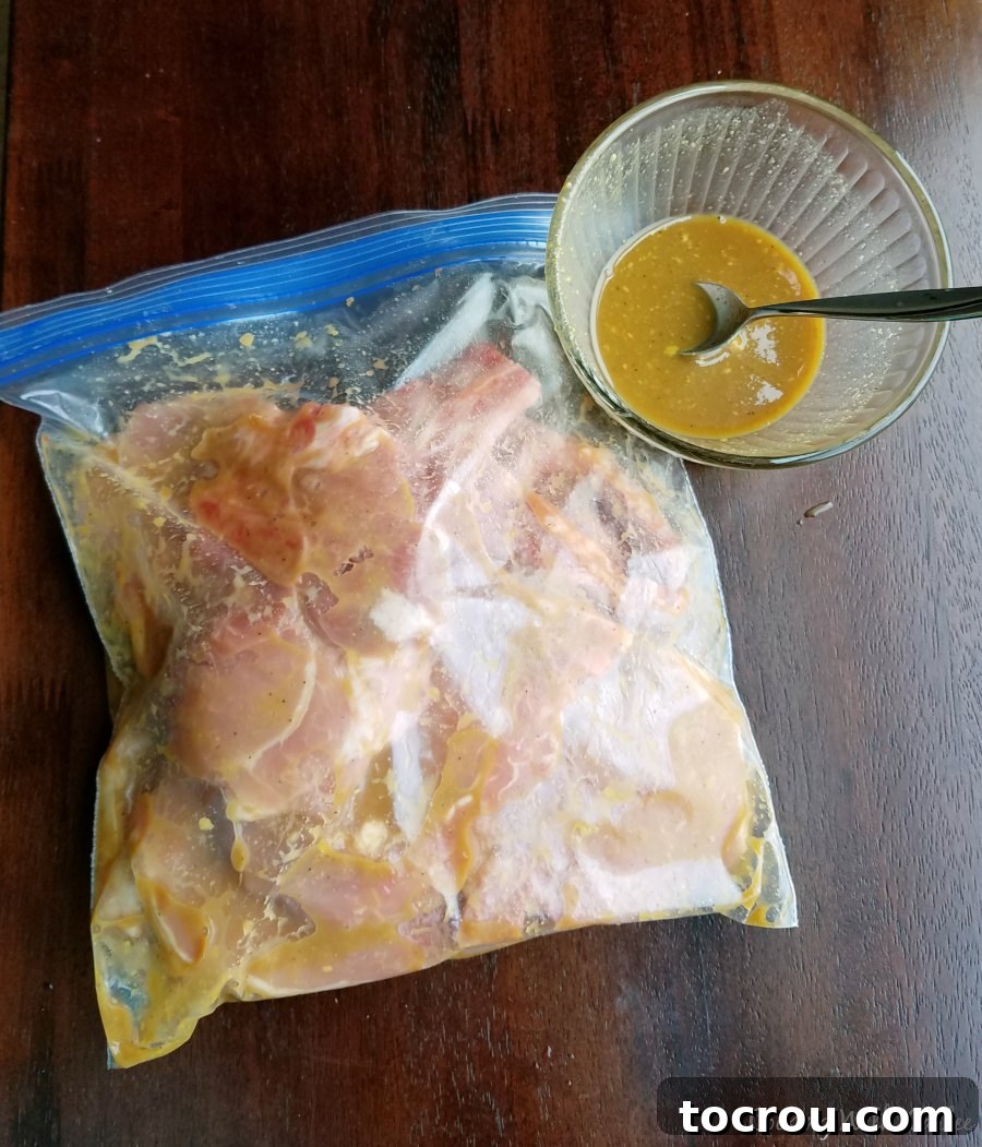 Golden Glazed Honey Mustard Chops 3 Bag of marinating pork chops with a little extra marinade in a bowl nearby.