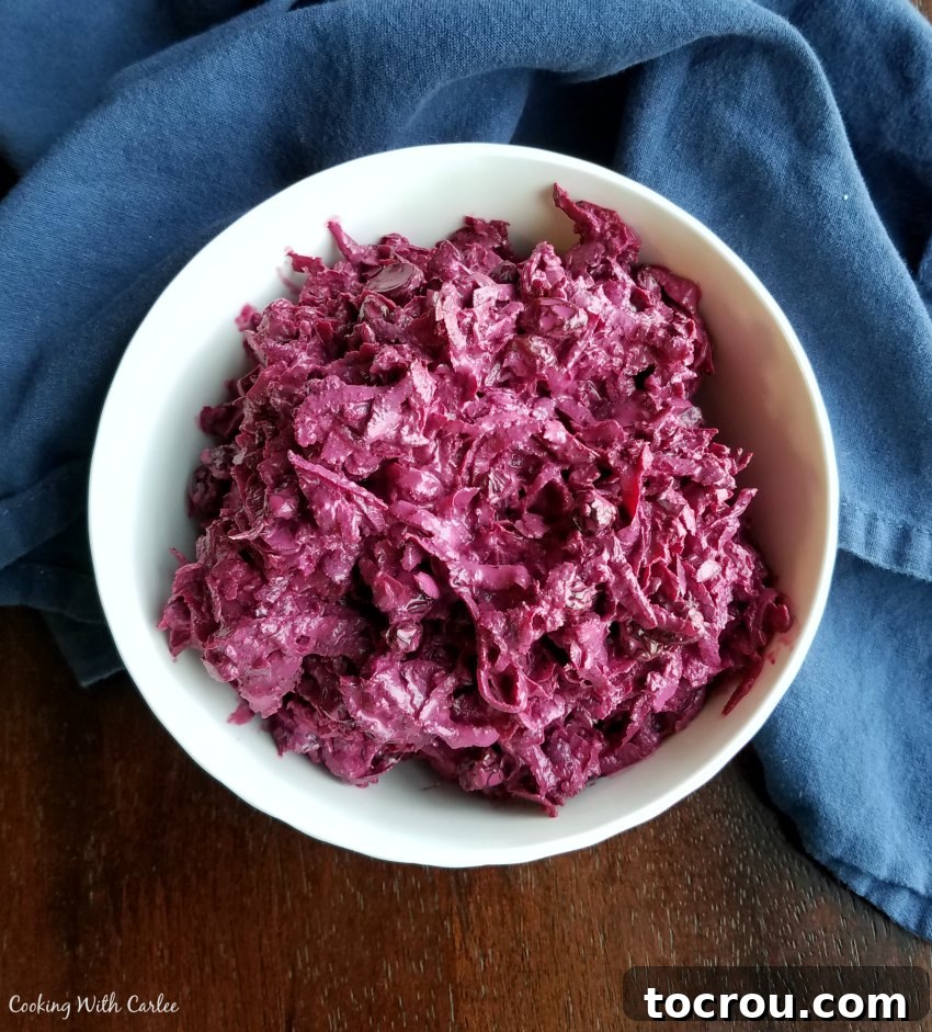 A wide shot of a bowl filled with shredded sour cream beet salad, beautifully showcasing its texture and vibrant color.