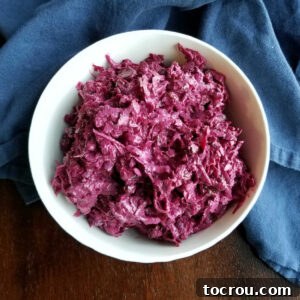 A beautifully presented bowl of Russian beet salad with shredded beets in a creamy sour cream dressing, ready to eat and garnished.