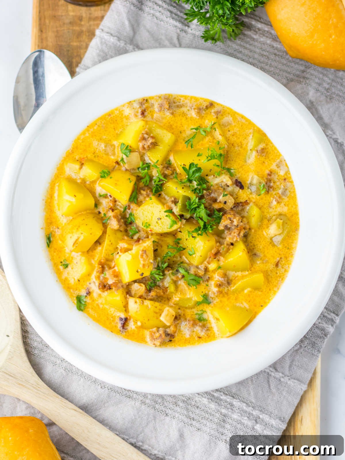 Close-up of Creamy Potato Soup Close-up view of a bowl of creamy potato soup with Italian sausage, showcasing large, tender chunks of golden potatoes, rich broth, and savory pieces of Italian sausage.