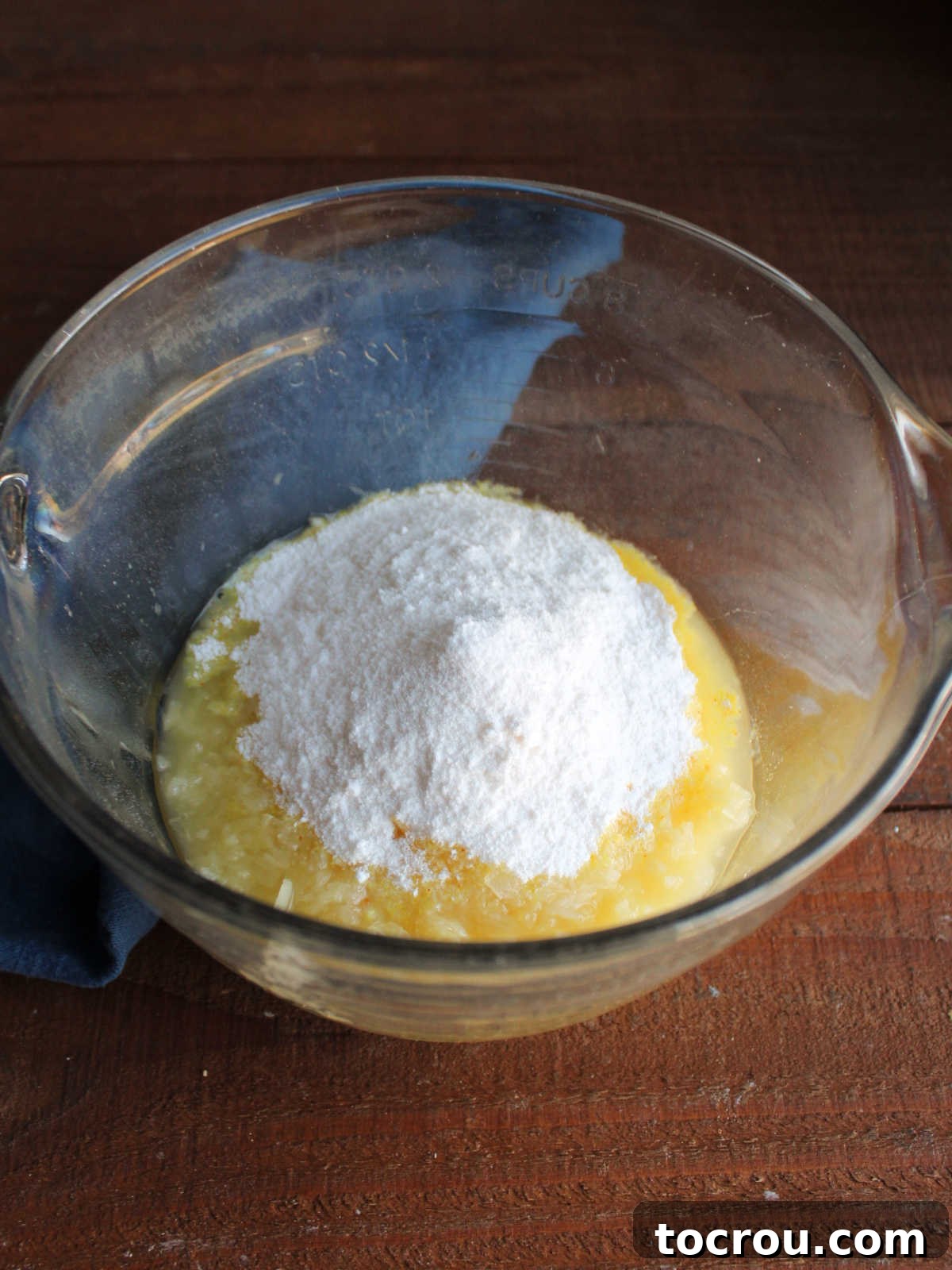Mixing instant vanilla pudding mix into crushed pineapple and its natural juices in a large bowl.