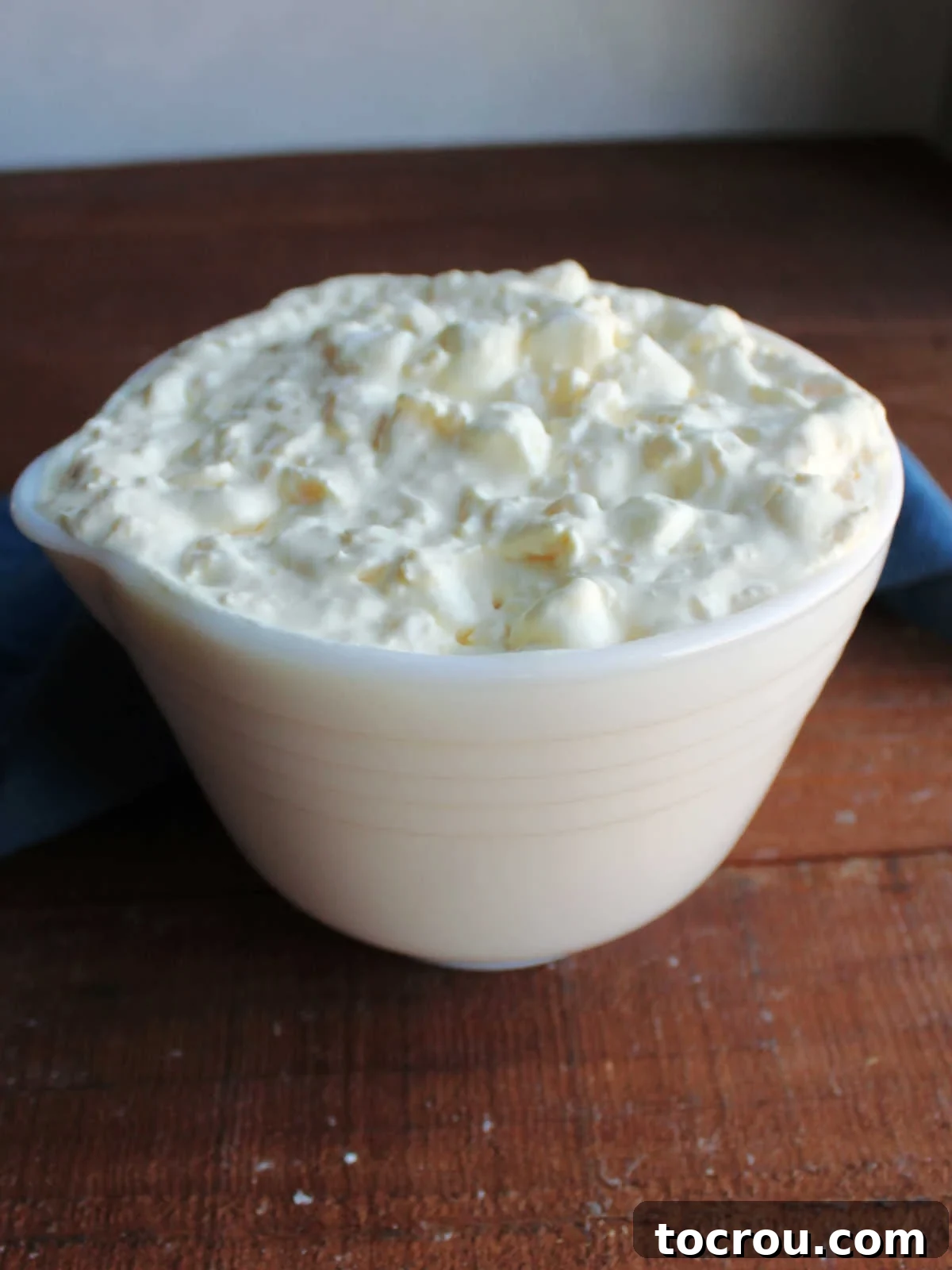 A vintage-style bowl elegantly filled with the creamy and inviting pineapple fluff mixture, perfectly ready to be served.