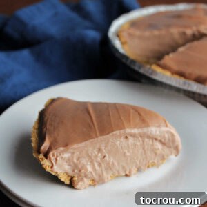 Slice of chocolate no bake cheesecake with condensed milk on plate with remaining pie in the background.