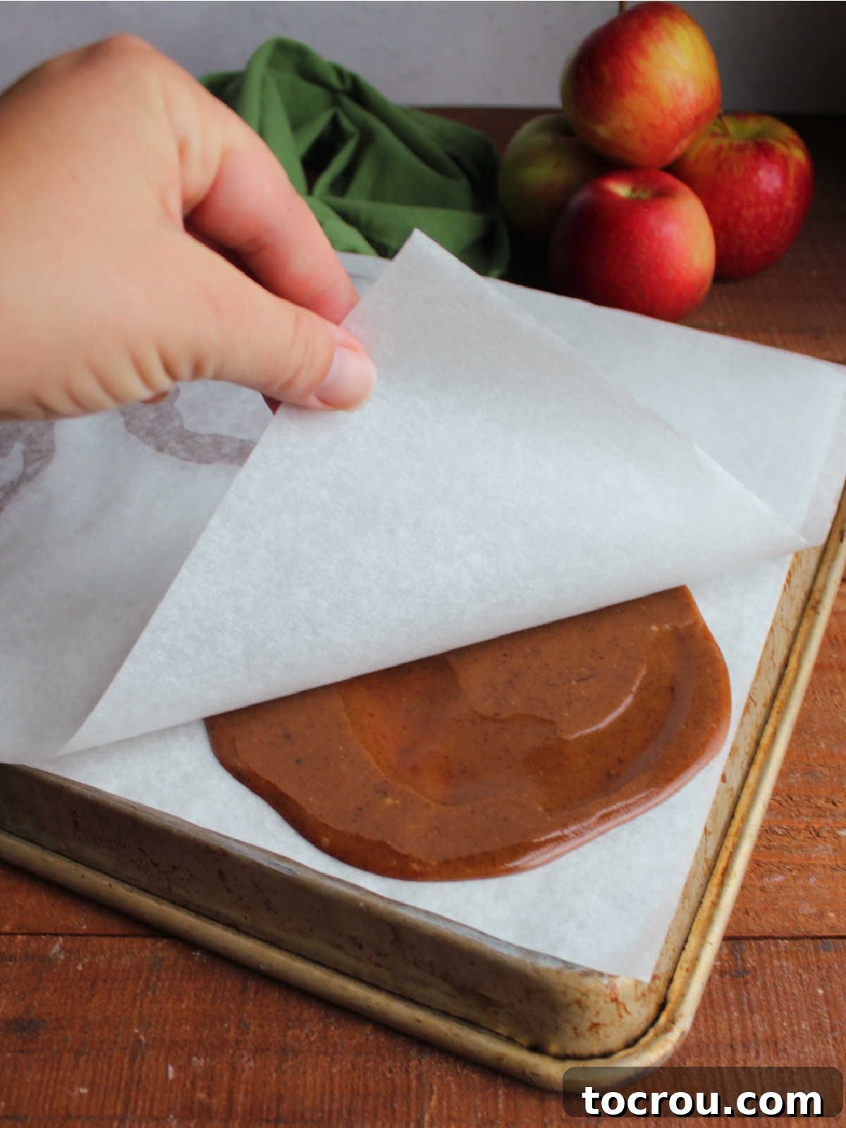 Pulling top layer of parchment paper off of caramel apple wraps, ready to use. 