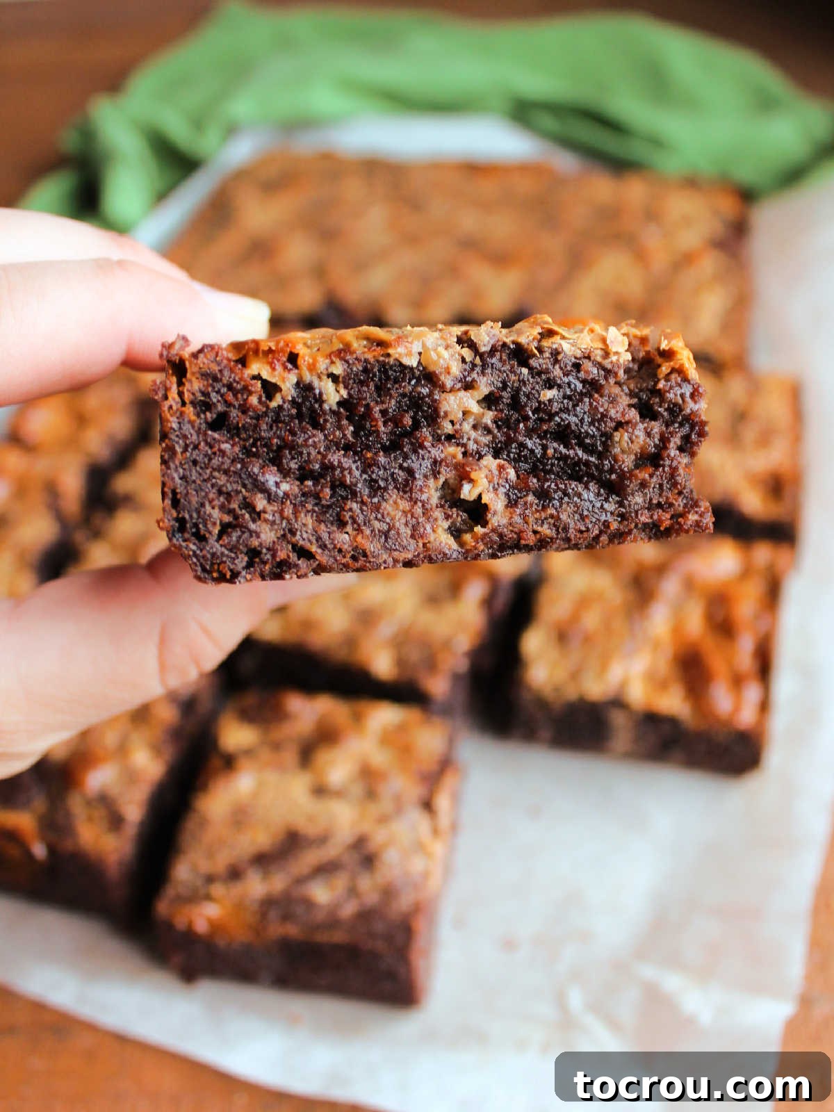 Hand holding a thick brownie mix brownie with caramelized condensed milk.