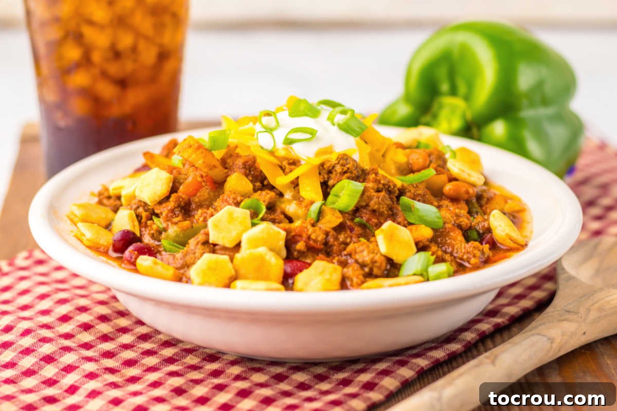 Bowl of Wendy's chili topped with sour cream, cheese and green onions, ready to be enjoyed.