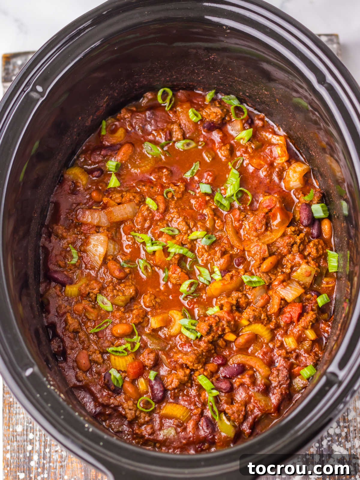 Cooked chili in the crockpot, showing the rich, thick consistency and well-integrated ingredients.