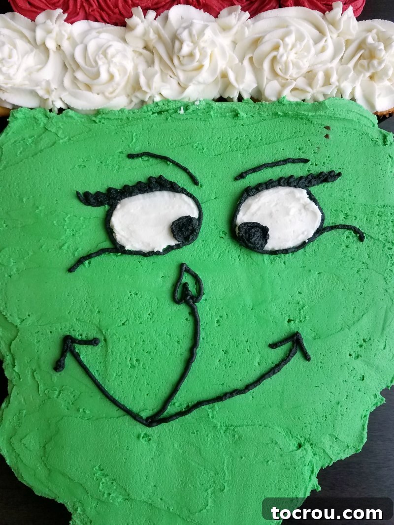 Close-up of the completed Grinch face on the pull-apart cupcake cake, showing intricate details.